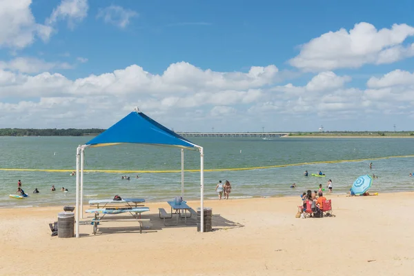 Texas, Usa-Haziran 16, 2018: waterfront Lynn Creek Park, Grand Prairie, Texas, güzel beyaz kum plaj. Yüzme, yüzen, grup kamp ve piknik lakeside çadırlar, bulut mavi gökyüzü, insanlar zevk