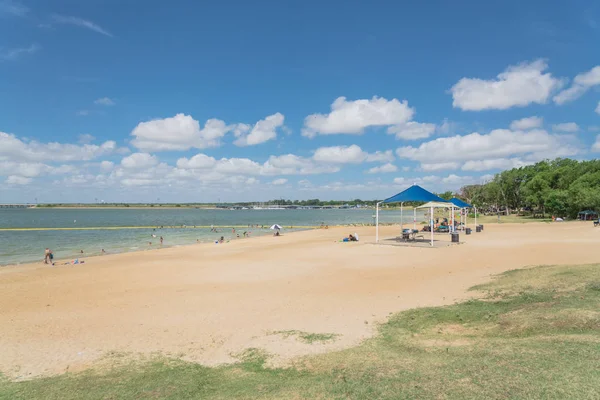 Texas, Usa-Haziran 16, 2018: waterfront Lynn Creek Park, Grand Prairie, Texas, güzel beyaz kum plaj. Yüzme, yüzen, grup kamp ve piknik lakeside çadırlar, bulut mavi gökyüzü, insanlar zevk