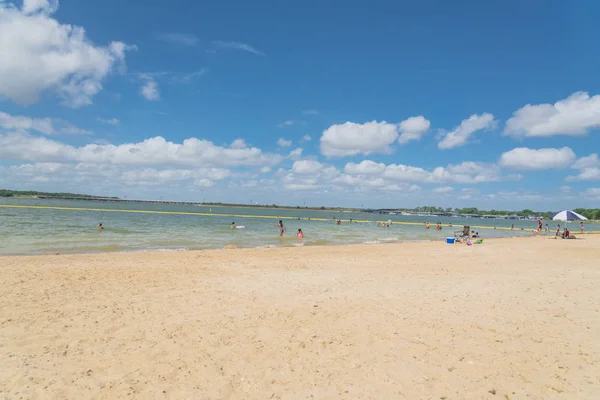 Texas, Usa-Haziran 16, 2018: waterfront Lynn Creek Park, Grand Prairie, Texas, güzel beyaz kum plaj. Yüzme, yüzen, grup kamp ve piknik lakeside çadırlar, bulut mavi gökyüzü, insanlar zevk