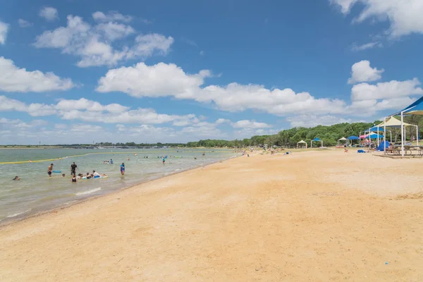 Texas, Usa-Haziran 16, 2018: waterfront Lynn Creek Park, Grand Prairie, Texas, güzel beyaz kum plaj. Yüzme, yüzen, grup kamp ve piknik lakeside çadırlar, bulut mavi gökyüzü, insanlar zevk