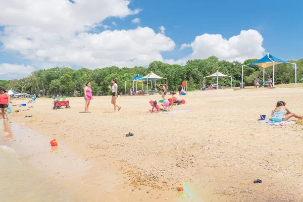 Texas, Usa-Haziran 16, 2018: waterfront Lynn Creek Park, Grand Prairie, Texas, güzel beyaz kum plaj. Yüzme, yüzen, grup kamp ve piknik lakeside çadırlar, bulut mavi gökyüzü, insanlar zevk