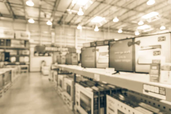 Vintage blurred electronic department store with row of TVs on shelves display. Television retail shop, TVs shelf wholesale store. Defocused warehouse interior technology aisle, inventory concept