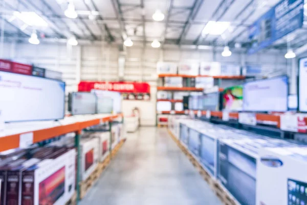 Vintage blurred electronic department store with row of TVs on shelves display. Television retail shop, TVs shelf wholesale store. Defocused warehouse interior technology aisle, inventory concept