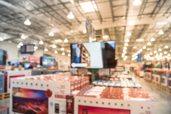 Blurred big screen fat TVs on display at wholesale store in USA