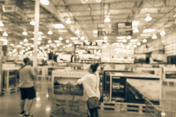 Vintage blurred customer shopping at electronic department, television retail shop. TVs display on shelf at wholesale store in USA. Defocused warehouse interior technology aisle, shelves, bokeh light