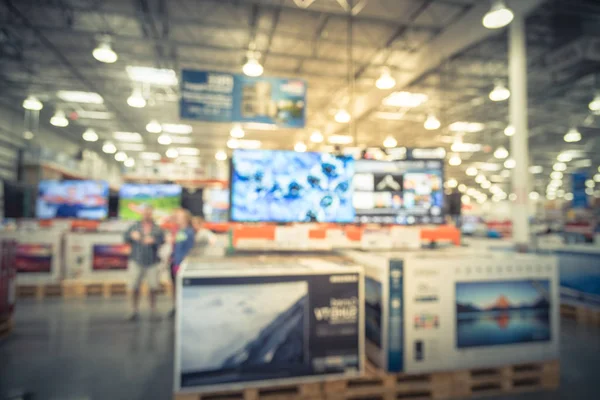 Blurred big screen fat TVs on display at wholesale store in USA