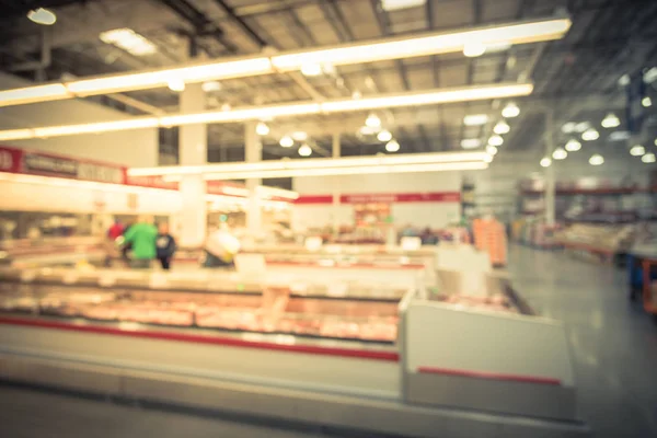 Vintage blurred image customers shopping for fresh raw beef, pork, chicken, fish at meat department in wholesale store in US. Fully loaded shelves variety of meat slices in boxes supermarket