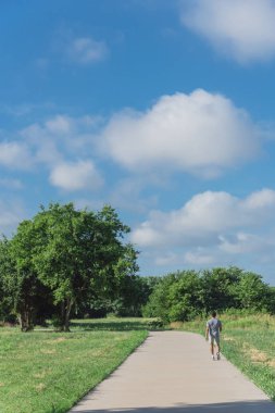 Arkadan görünüm etkin bir Asyalı adamın Park'ta sabahın erken saatlerinde koşu. Sağlıklı yaşam konsepti