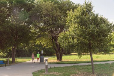 Aktif çift Park'ta sabahın erken saatlerinde koşu görünümünü arka. Yol üzerinde egzersiz insanlar. Sağlıklı yaşam konsepti