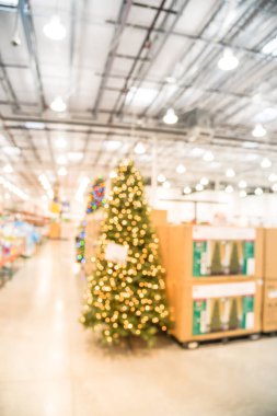 Toptan mağaza bulanık görüntü büyük Noel ağacı süsle. Çelenk ve dizeleri bokeh ışıkların yapay Noel ağacı surround. Amerika'da satış için görüntülenen Noel süsleri.