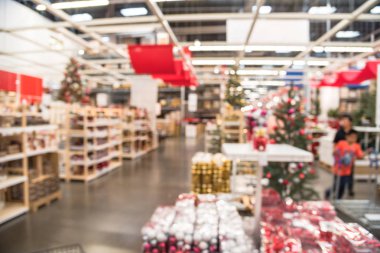 Bulanık renkli satır, raflar plastik Noel zil süsler, çelenk, satışında büyük mobilya mağazası aydınlatma ve suni Noel ağacı süsle. Bokeh açık renkli. Oynayan çocuklar.