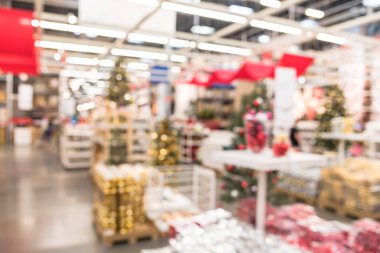 Bulanık renkli satır, raflar plastik Noel zil süsler, çelenk, aydınlatmalar ve büyük mobilya depo satışında yapay Noel ağacı süsle. Bokeh ışıklar arka plan.