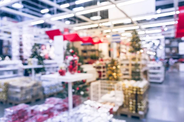 Bulanık renkli satır, raflar plastik Noel zil süsler, çelenk, aydınlatmalar ve büyük mobilya depo satışında yapay Noel ağacı süsle. Bokeh ışıklar arka plan.
