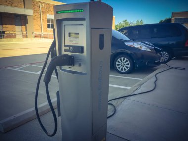 Elektrikli arabaya takılı şarj cihazı ile şarj istasyonu yakın çekim. Şarj edilebilir piller araç park çok az yakıt ikmali. Kavramı gelecekteki otomobil ve ulaşım