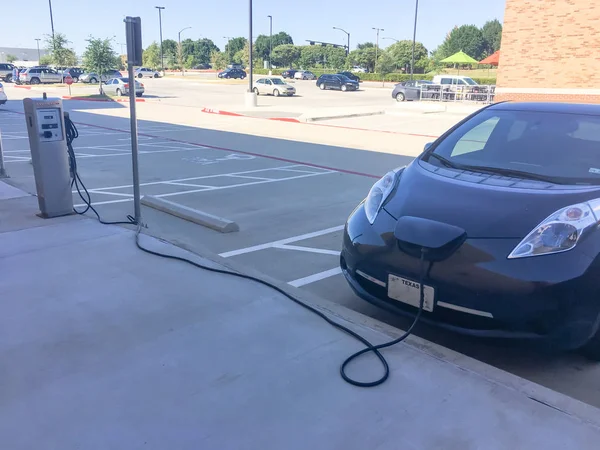 Elektrikli otomobil başlık takılı şarj cihazı ile şarj istasyonu. Şarj edilebilir piller araç yakıt ikmali, otoparklar ABD perakende mağaza. Kavramı gelecekteki otomobil ve ulaşım