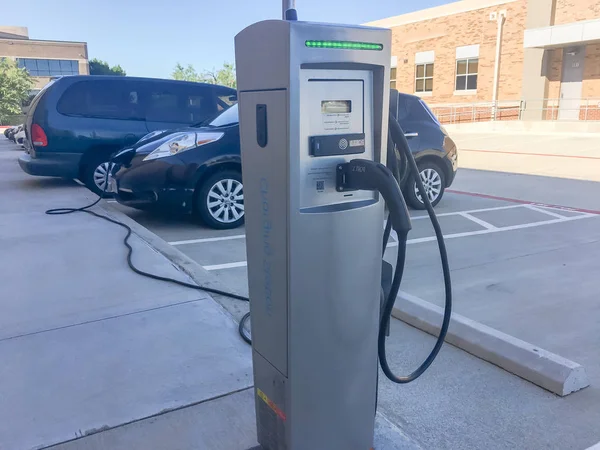 Elektrikli arabaya takılı şarj cihazı ile şarj istasyonu yakın çekim. Şarj edilebilir piller araç park çok az yakıt ikmali. Kavramı gelecekteki otomobil ve ulaşım