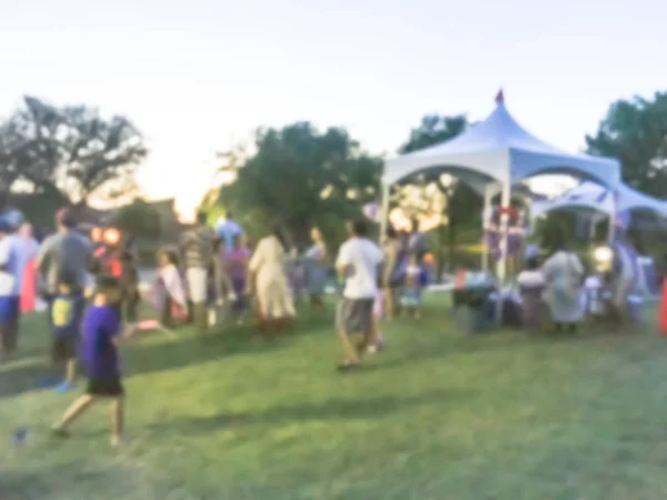 日の地元住民の動きぼやけの多様なグループのお祝いイベントです 抽象的な背景の 日主催者ブース アーヴィング テキサス州 アメリカ合衆国のテントで夜を祝う — ストック写真