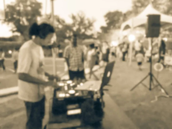 Blurred close-up of DJ mixing music on DJ performance controller with integrated laptop stand. DJ mixing track at local event in Irving, Texas, USA. Music festival and entertainment concept