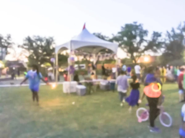 日の地元住民の動きぼやけの多様なグループのお祝いイベントです 抽象的な背景の 日主催者ブース アーヴィング テキサス州 アメリカ合衆国のテントで夜を祝う — ストック写真