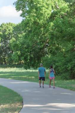 Aktif çift Park'ta sabahın erken saatlerinde koşu görünümünü arka. Yol üzerinde egzersiz insanlar. Sağlıklı yaşam konsepti
