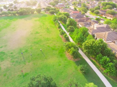 İnsanların spor oynamak, yeşil çayır on egzersiz ile Konut Evleri yakın hava büyük park. Kentsel rekreasyon çevreleyen Houston, Texas, yeşil ağaç tarafından yeşil bize... Sıkıca paketlenmiş evler mahalle