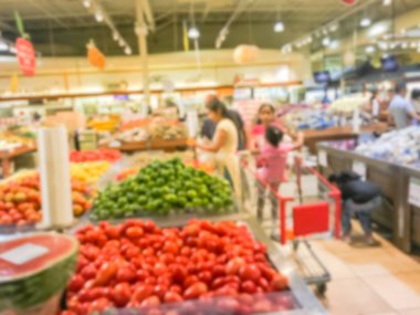 Bulanık müşteri alışveriş için taze sebze, meyve bakkal Texas, Usa. Çeşitli organik ve yerel olarak yetiştirilen ekranda üretir. Süpermarkette sağlıklı gıda arka plan