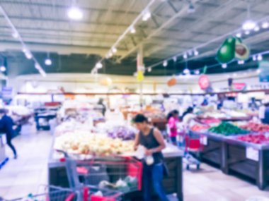 Bulanık müşteri alışveriş için taze sebze, meyve bakkal Texas, Usa. Çeşitli organik ve yerel olarak yetiştirilen ekranda üretir. Süpermarkette sağlıklı gıda arka plan