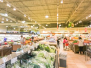 Bulanık müşteri alışveriş için taze sebze, meyve bakkal Texas, Usa. Çeşitli organik ve yerel olarak yetiştirilen ekranda üretir. Süpermarkette sağlıklı gıda arka plan