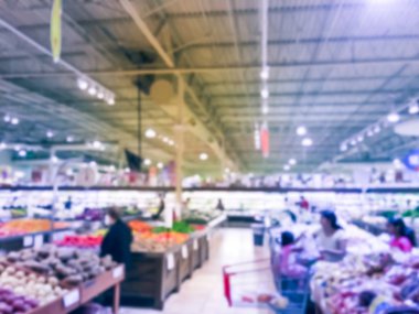 Bulanık müşteri alışveriş için taze sebze, meyve bakkal Texas, Usa. Çeşitli organik ve yerel olarak yetiştirilen ekranda üretir. Süpermarkette sağlıklı gıda arka plan