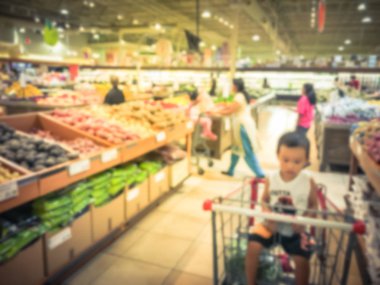 Bulanık müşteri alışveriş için taze sebze, meyve bakkal Texas, Usa. Çeşitli organik ve yerel olarak yetiştirilen ekranda üretir. Süpermarkette sağlıklı gıda arka plan