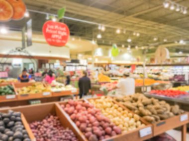 Bulanık müşteri alışveriş için taze sebze, meyve bakkal Texas, Usa. Çeşitli organik ve yerel olarak yetiştirilen ekranda üretir. Süpermarkette sağlıklı gıda arka plan