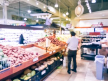 Bulanık müşteri alışveriş için taze sebze, meyve bakkal Texas, Usa. Çeşitli organik ve yerel olarak yetiştirilen ekranda üretir. Süpermarkette sağlıklı gıda arka plan