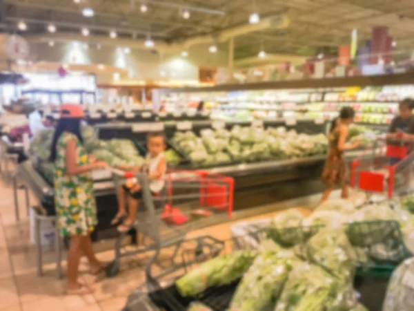 Blurred customer shopping for fresh vegetables, fruits at grocery store in Texas, USA. Variety of organic and locally grown produces on display. Healthy food abstract background in supermarket