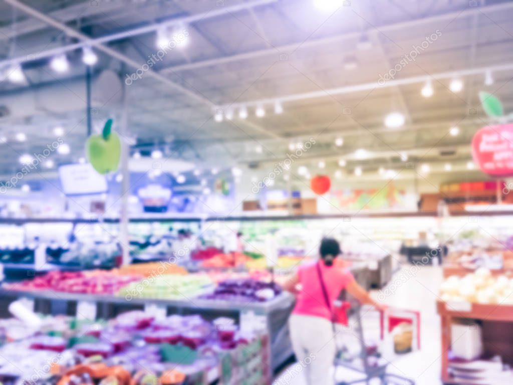 Blurred motion variety of fresh fruits at local grocery store in USA with customer shopping. Seasonal raw fruits, produces on shelves at supermarket  in Texas. Abstract healthy lifestyle concept