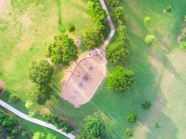 Houston, Texas Harwin Park'ta bir koca çocuk oyun bahçesi hava görünümünü. Slaytlar ve salıncaklar parkta yeşil ağaçlarıyla çevrili yükseltilmiş bir bakış. Çocuk açık oyun ve eğlence kavramı.