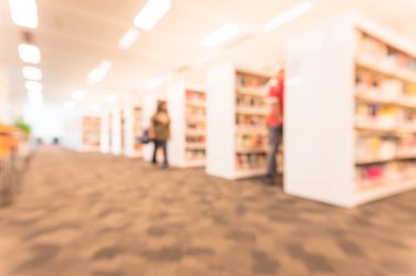 Halk Kütüphanesi iç arka plan bulanık. Bir kız öğrencinin bookshelf koridorları satır ders kitapları, edebiyat dolu yürüyorduk. Oturma alanı ve sol tarafta okumak için Fakülte.