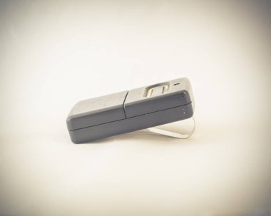 Yakın çekim studio garaj kumandası beyaz arka plan üzerinde izole güneşlik klipsli bir kadeh. Kopya alanı ile siyah kablosuz kapı açacağı. Bir düğme garaj kapı gönderici, alıcı