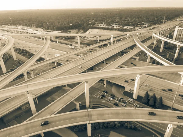 Vintage tone aerial view massive highway intersection, stack interchange with elevated road junction overpass in Houston, Texas, USA. Five-level freeway interchange carry heavy rush hour traffic