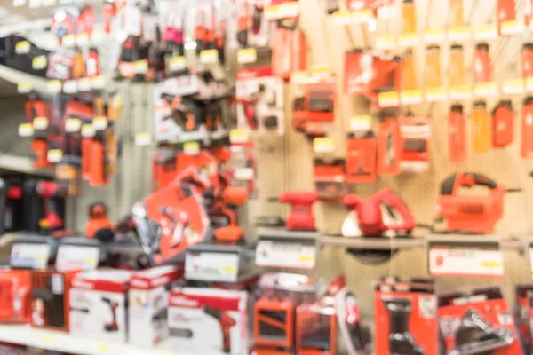 Blurred variety of power tools at tools department in local store Humble, Texas, US. Row of cordless drills, driver, jigsaw, circular saw kit and drill bits. Depicting carpentry and construction tools