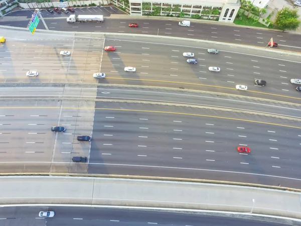 Top view of an asphalt elevated highway in Houston, Texas, US. Many passenger cars and trucks are commuting in freeway at late afternoon with warm light. Great for urban transportation publication.