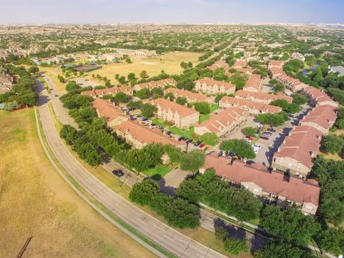 Üstten görünüm park yan apartman ve Irving, Texas, ABD yerel Caddesi yakınındaki konut ev. Otoparklar, arabalar ve çok katlı binalar karmaşık ağaçlara havadan görünümü kaplı