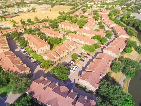 Aerial view apartment buildings complex near recreational park and canal in Irving, Texas, USA.