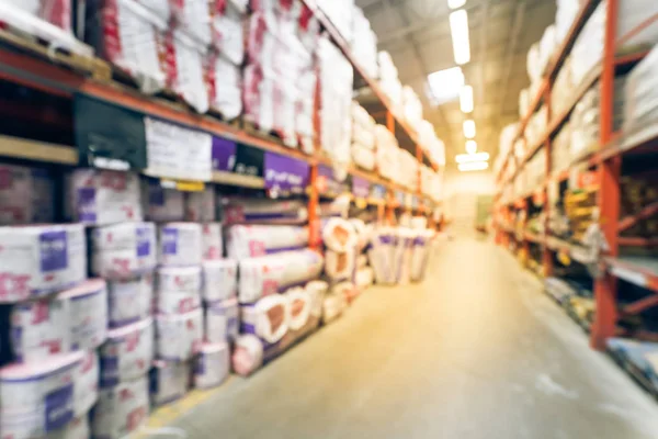 Vintage blurred a large hardware store. Defocused interior of home improvement retailer with racks, aisles of building material insulation from floor to ceiling. Construction wholesale concept