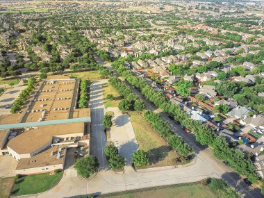 Irving, Texas, ABD konut evler yakınındaki hava görünümünü okul bölgesi. İlköğretim Okulu tarafından yeşil ağaç çevreler. Kentsel sıkı paketlenmiş evler mahalle, driveways, daire karmaşık köprü