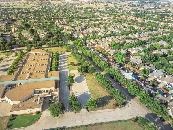 Irving, Texas, ABD konut evler yakınındaki hava görünümünü okul bölgesi. İlköğretim Okulu tarafından yeşil ağaç çevreler. Kentsel sıkı paketlenmiş evler mahalle, driveways, daire karmaşık köprü