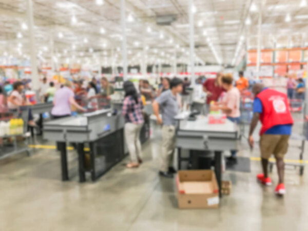 Wholesale shopping, sale, payment, consumerism and people concept. Blurred image cashier with long line of customer with clerk support at check-out counter of warehouse store in America