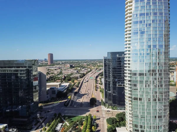 Dallas downtown landmark buildings and Woodall Rodgers Freeway (Texas Highway 366) aerial. Modern skyscrapers under summer cloud blue sky. Cityscape and transportation background