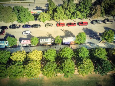 Vintage üst sıra yemek ve gıda teslim kavşak çevreleyen üzerinde satmak için renkli telefon gıda kamyon satıcıları ile yeşil kent park görüntüleyin. Sokak gıda sanayi hava kavramı
