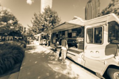 Vintage bulanık gıda kamyon satıcı müşteriler satın almak ve gıdaların çeşitli tat. Dallas, Texas, ABD, mavi gökyüzü geniş görüş kentsel Park'ta öğle yemeği ve içecek teslimat almak için bekliyor, sıraya queuing insanlar