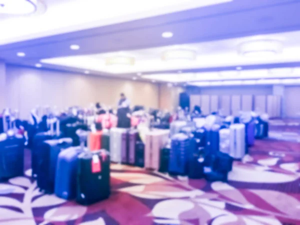 Abstract blurred luggage storage room at a luxury hotel in San Francisco, California, USA. Available for guests who want to leave bags. An unidentified employee is arranging, stack multicolor suitcase